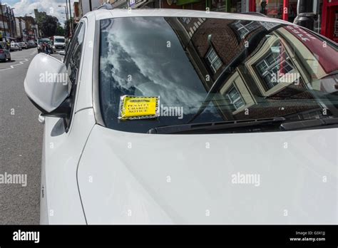 Penalty Charge Notice Parking Fine Attached To Windscreen Of White Car Parked In High Street